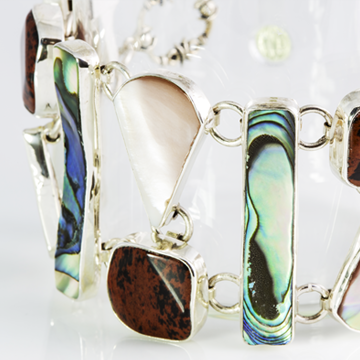 The sea and the volcano come together in this bracelet. .925 Sterling Silver, Obsidian, abalone and shell